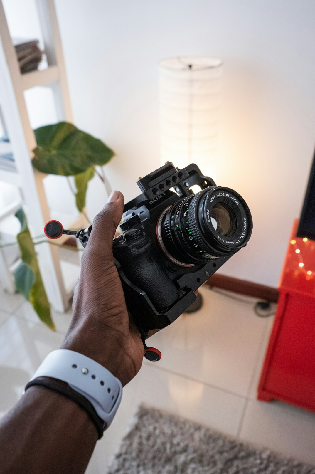 Black filmmaker in his thirties holding a video camera in a bright studio